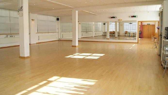 Spacious STUDIO 1 with polished floors, ideal for fitness classes and workshops.